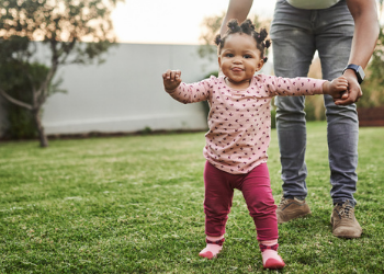 a toddler playing with her dad at the backyard